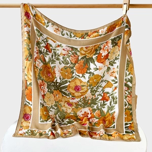 Close-up of retro floral print silk square scarf with yellow borders and vivid patterns