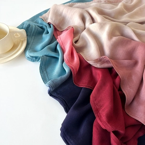 Elegant solid color silk scarves in multiple shades layered with premium edge stitching