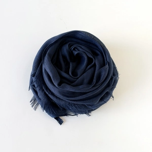 Close-up of lightweight navy blue cotton linen scarf featuring detailed tassel edges