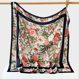 Detail of vintage floral print silk scarf with navy geometric border and soft drape