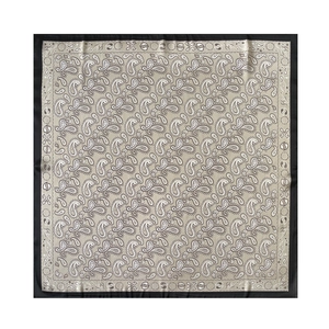 Vista dettagliata di un foulard in seta con motivo paisley classico beige e nero