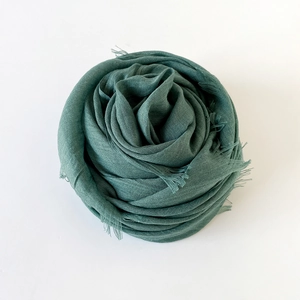 Detailed close-up of Morandi green cotton linen scarf showing soft fringe and fabric texture