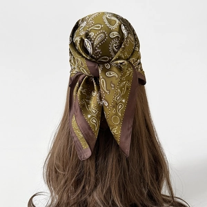 Vista posteriore della modella che indossa un foulard di seta verde oliva con paisley