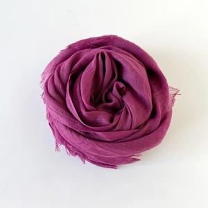 Detail of plum red cotton linen scarf with soft fringe edges and delicate woven texture