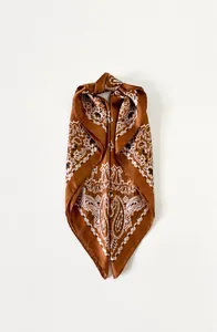 Detailweergave van een karamelkleurige zijden sjaal met vintage paisley-patronen en textuur