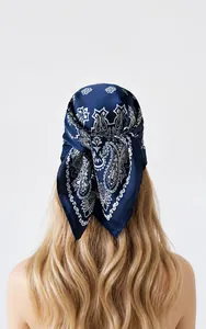 Detail van een diepblauwe zijden sjaal met paisley-motief gedragen als hoofddoek