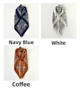 Detailweergave van paisley satijnen sjaals in marineblauw, parelwit en retro koffietinten