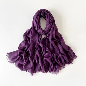 Primer plano del chal de lino violeta oscuro con textura suave y detalles de flecos