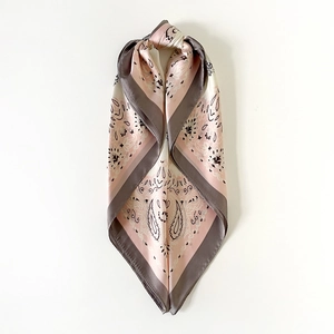 Detail of satin square scarf featuring pink and grey paisley patterns with elegant drape
