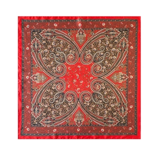 Detail view of red paisley pattern and floral motifs on a silky square headscarf