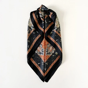 Detailed close-up of retro paisley print satin scarf showing smooth silk texture and drape
