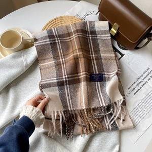 Close-up of winter plaid scarf with fringe tassels and quality blend fabric tag