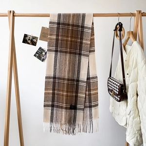 Close-up of 100% wool check scarf with fringe details in brown and beige tones