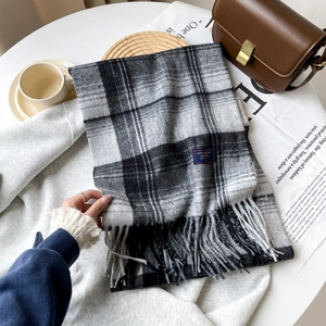 Detailed macro shot of classic black, grey and white plaid scarf with tassel fringe edges
