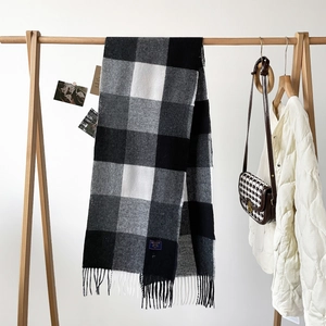 Macro shot of thick black and white plaid scarf texture with soft fringe details
