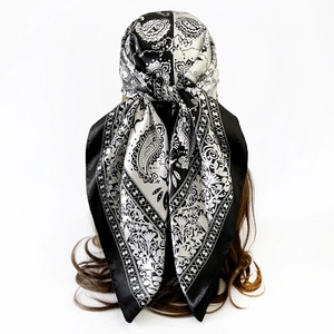 Detail of a 90cm black and white paisley silk scarf tied as a headpiece for women