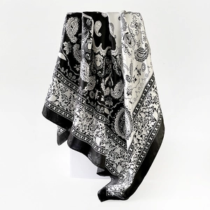 Detail of a 90cm square silk scarf featuring black and white paisley floral patterns