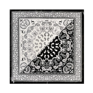 Detailed overhead shot of square silk scarf with black and white paisley patterns
