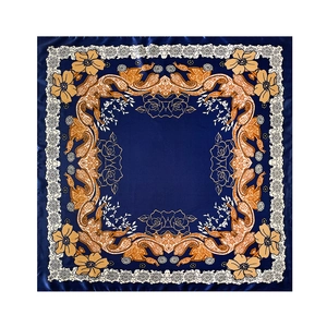 Flat lay view of a navy blue square silk scarf with yellow paisley floral patterns
