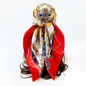 Rear view of a red silk scarf with golden chain print styled as a classic headwrap