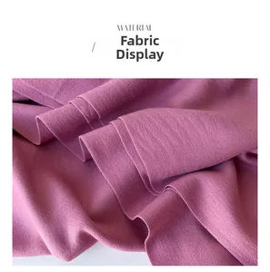 Close-up of plum purple cashmere-like fabric showing twill weave texture and drape