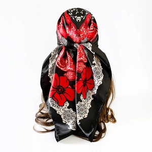 Detail of satin floral scarf with red paisley print on shiny black and white fabric