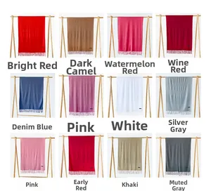 Macro shot of 12 multi-colored cashmere-style scarves with fringe details on wood stands
