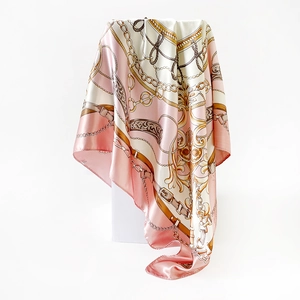 Detailed close-up of chain print satin scarf with elegant golden and pink drapery