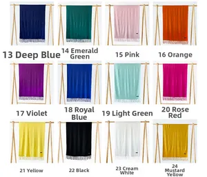 Detailed grid of twelve solid-colored cashmere-like scarves with long fringe details