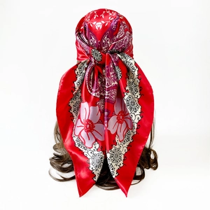 Detail of red satin headscarf with purple paisley and floral patterns on mannequin