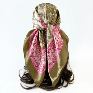 Detail view of paisley silk scarf styled as headwrap on hair with pink and green pattern