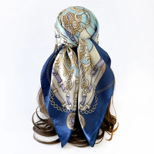 Detail of a satin square scarf featuring classic golden chains and baroque patterns