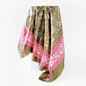 Detail showing the silky texture of paisley floral print silk scarf in olive and magenta