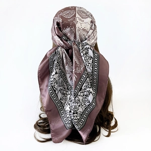 Detail showing the paisley pattern silk scarf worn as a retro headwrap on a model