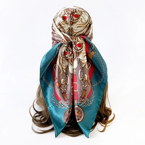Baroque chain print silk headscarf detail with golden buckle and red jewel patterns