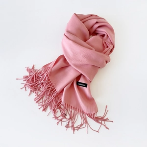 Close-up of pink cashmere scarf with fringe tassels and high-quality fabric texture