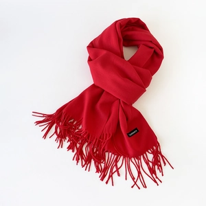 Detail of red cashmere scarf showing fine texture, long tassels, and authentic labels