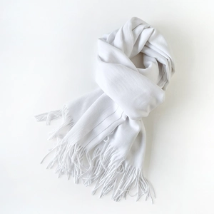 Close-up of pure white soft blend scarf with dense fine tassel details on edges