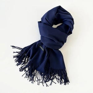 Detail view of premium dark blue cashmere scarf showing soft texture and fringe edges
