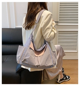 Detail showing the large capacity and lightweight nylon fabric of this lilac crossbody bag