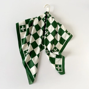 Carré de soie satiné à damier vert avec motifs floraux sur un fond blanc épuré