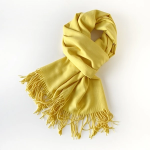 Detailed view of ginger yellow scarf featuring soft texture and long fringe tassels