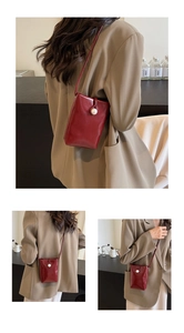 Detail of red glossy leather mini crossbody bag with a large pearl decorative buckle