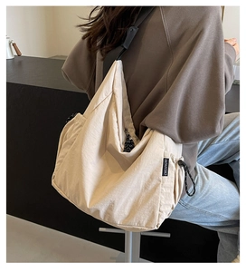 Detailed back view of a beige canvas crossbody bag with drawstring and adjustable strap