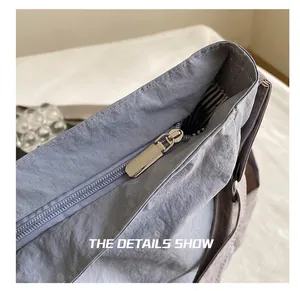 Detail view of the smooth metal zipper and blue striped lining of the canvas crossbody bag