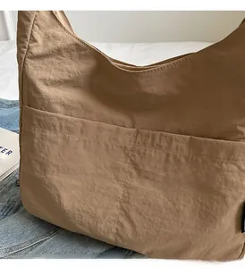Detail of camel nylon tote bag with large front pocket and double stitching details