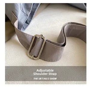 Detail of adjustable shoulder strap with silver buckle on lavender canvas messenger bag