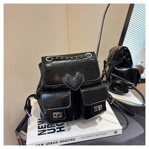 Detail of a black mini bucket backpack with heart stitching and silver hardware