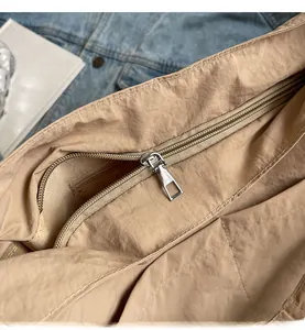 Detail of khaki nylon shoulder bag with smooth metal zipper and internal pocket