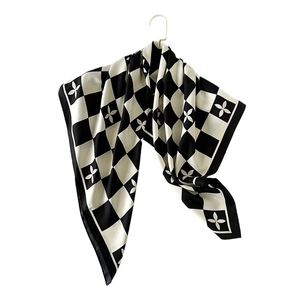 Carré de soie tendance à damier noir et blanc avec motifs floraux sur un crochet doré